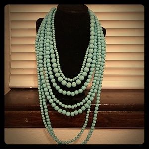 Turquoise colored multi-strand bead necklace.